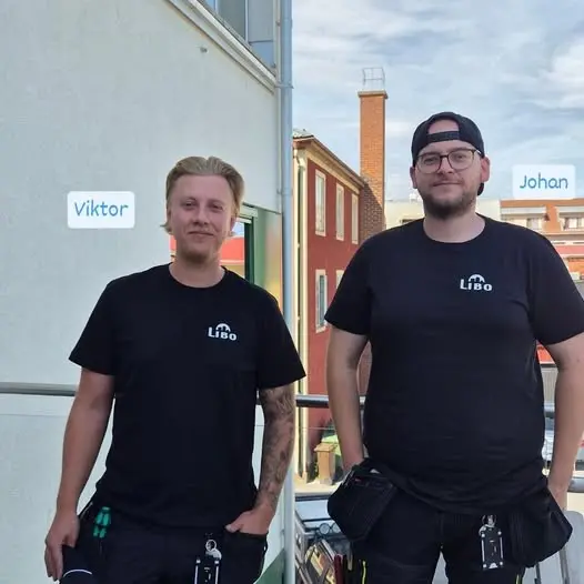 Två män i svarta tröjor varav en har en keps bak och fram.