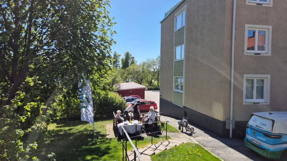 Människor som sitter och samtalar i solen.
